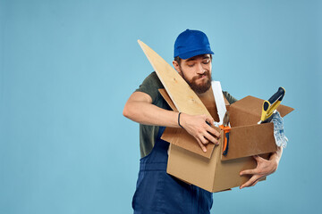 Worker man in uniform box tools construction blue background