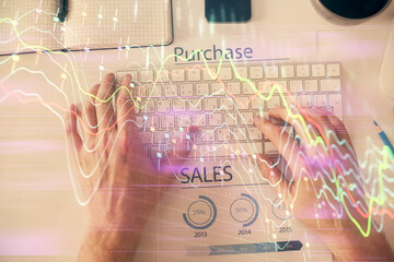 Double exposure of man's hands typing over laptop keyboard and forex chart hologram drawing. Top view. Financial markets concept.
