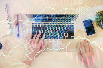 Multi exposure of woman hands working on computer and forex chart hologram drawing. Top View....