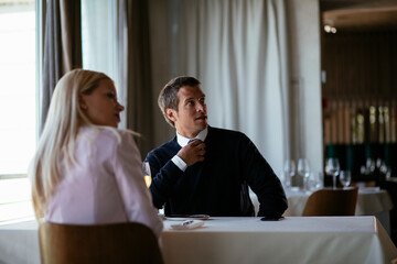 Handsome businessman dressed in the suit drinking wine. Businessman enjoying in the restaurant