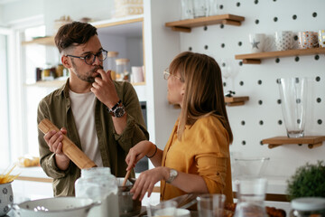 Young couple preparing delicious food at home. Loving couple enjoying in the kitchen.