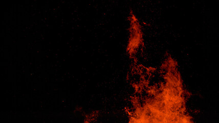 CLOSE UP: Fiery orange flames flicker high into the pitch black night sky.