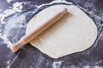 simple food ingredients, pizza chef rolling pizza dough with rolling pin