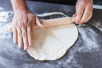 simple food ingredients, pizza chef rolling pizza dough with rolling pin