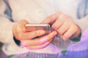 Fototapeta premium Multi exposure of man's hands holding and using a digital phone and forex graph drawing. Financial market concept.