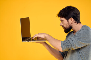 man with laptop wireless technology internet lifestyle work yellow isolated background