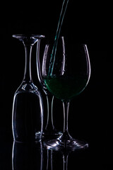
set of glasses with black background and serving green liquid