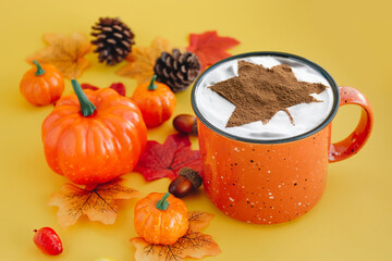 Hot coffee in bright orange cup with leaves and pumpkins. Autumn harvest concept - 384659137