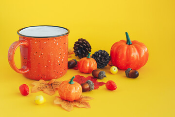 Coffee, pumpkins, spruce cones, acorns and leaves on yellow background. Autumn composition
