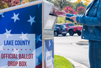 Vernon Hills, IL/USA - 10-10-2020:  Woman voting by mail using official ballot drop box