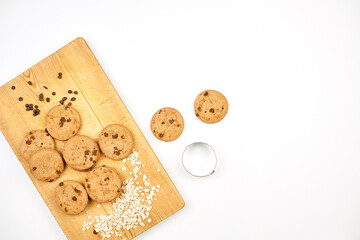 Sweet cookies on the wooden cutting board. Gluten-free oatmeal cookies on pure white fabric