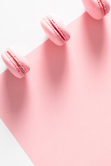 Pink macaroons on pink and white background. Almond cookies as  background. Sweet french macaroon. Flat lay, top view, copy space. Flat lay, top view, copy space