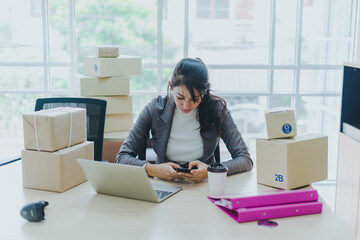 A beautiful businesswoman working at home is checking orders for products to be delivered to her customers from notebooks.