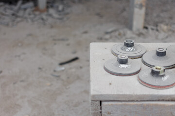 Polishing discs for a grinder in a dusty granite workshop.