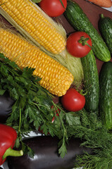 Ripe corn and fresh vegetables on a cutting board