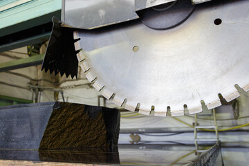 Large disc of a stone cutting machine over a granite stone.