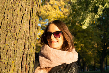 Portrait of a young woman posing against a tree