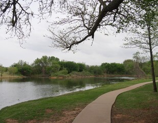 Nature view of a lake with a concrete walkway for joggers