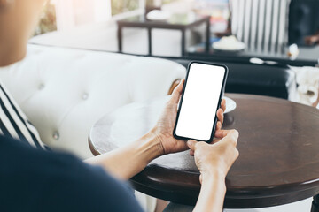 cell phone mockup blank white screen.woman hand holding texting using mobile on desk at coffee shop.background empty space for advertise.work people contact marketing business,technology