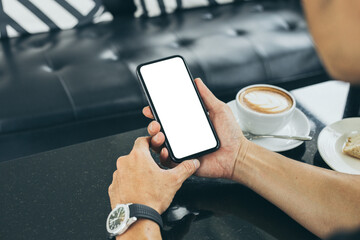 cell phone mockup blank white screen.man hand holding texting using mobile on desk at coffee shop.background empty space for advertise.work people contact marketing business,technology