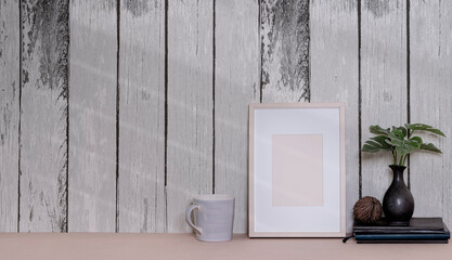 Mockup blank wooden picture frame on the table with old wooden wall, copy space.
