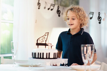 Music and piano birthday party. Kid with cake.