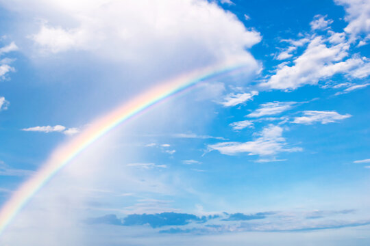 Beautiful colorful rainbow after rain against the blue sky. Background image