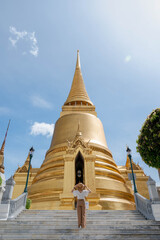 Fototapeta premium The back view of woman wearing hat for protect the sun travel at the Grand palace.