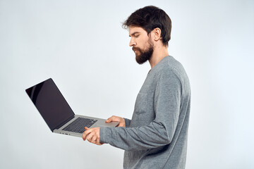 A man in a gray sweater with a laptop hands lifestyle technology communication internet work