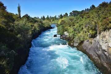 Fototapeta na wymiar New Zealand, normally 100m wide Waikato River continues like a narrow 15m wide gorge. Huka Falls is the phenomenon of natural hydro power - more than 220, 000 litres of water per second.