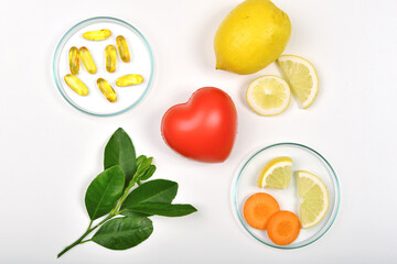 Heart model and Vitamin nutrition pills with fresh fruit and vegetable, Healthy diet, Vitamin and mineral supplement, Nutrition food as a prescription for good health.