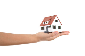 Fototapeta na wymiar A hand holding a small house model in front of a white background