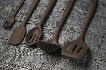 Set of silicone kitchen accessories on a wooden background.