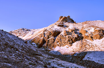 Crown shaped rock covered with snow against a blue sky in the soft light of the morning sun
