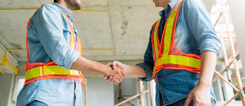 Two Civil Engineer or Architect wearing helmet and handshaking together .architecture and home renov
