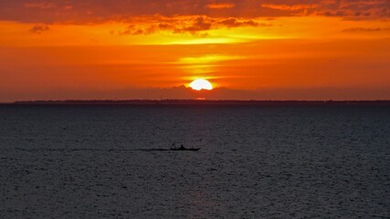 sunset over the sea, With small fishing boat.