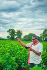 indian farmer checking with test tube and tablet at field