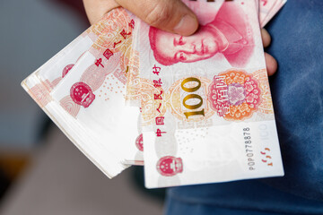 Man holds yuan. Currency of the China - One red hundred renminbi or yuan notes