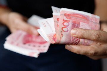 Man gives yuan. Currency of the China - One red hundred renminbi or yuan notes