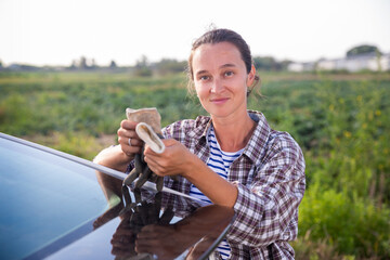 Confident woman farmer standing near car on farm outdoors © JackF