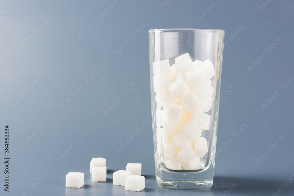 Wall mural a glass full of white sugar cube sweet food ingredient, studio shot isolated on a gray background, h