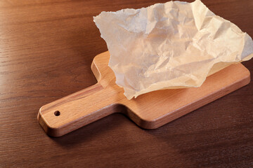 Parchment for serving dishes on a wooden board. European cuisine.