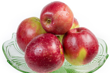 Washed red apples in the glass dish close-up