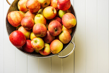 Ripe red apples and watermelon in washtub on white wooden background top view