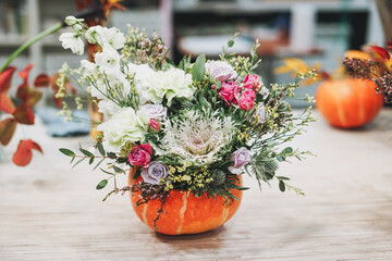 DIY autumn flower arrangement bouquet in pumpkin at the floristry studio