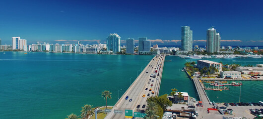 Miami, Florida. Aerial view of MacArthur Causeway and surrounding skyline from drone on a sunny day. - obrazy, fototapety, plakaty