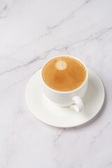 Obraz na płótnie Canvas a cup of black coffee in a white cup on a dark background.