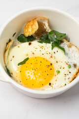 fried egg in a white plate on a white background.