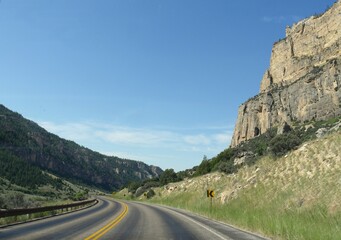 Wide view of scenic a road along high rock walls through the Bighorn Mountains in Wyoming.