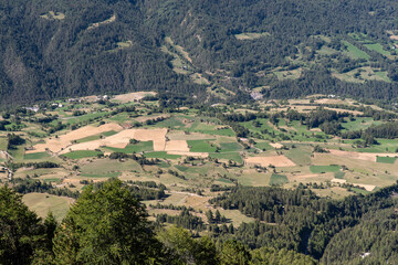 Fototapeta na wymiar Different fields cultivated in the valley in the mountains in the Alps in France